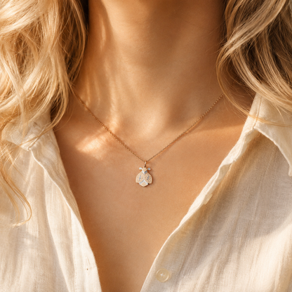 Ladybug necklace worn by model in warm golden hour light with cream shirt
