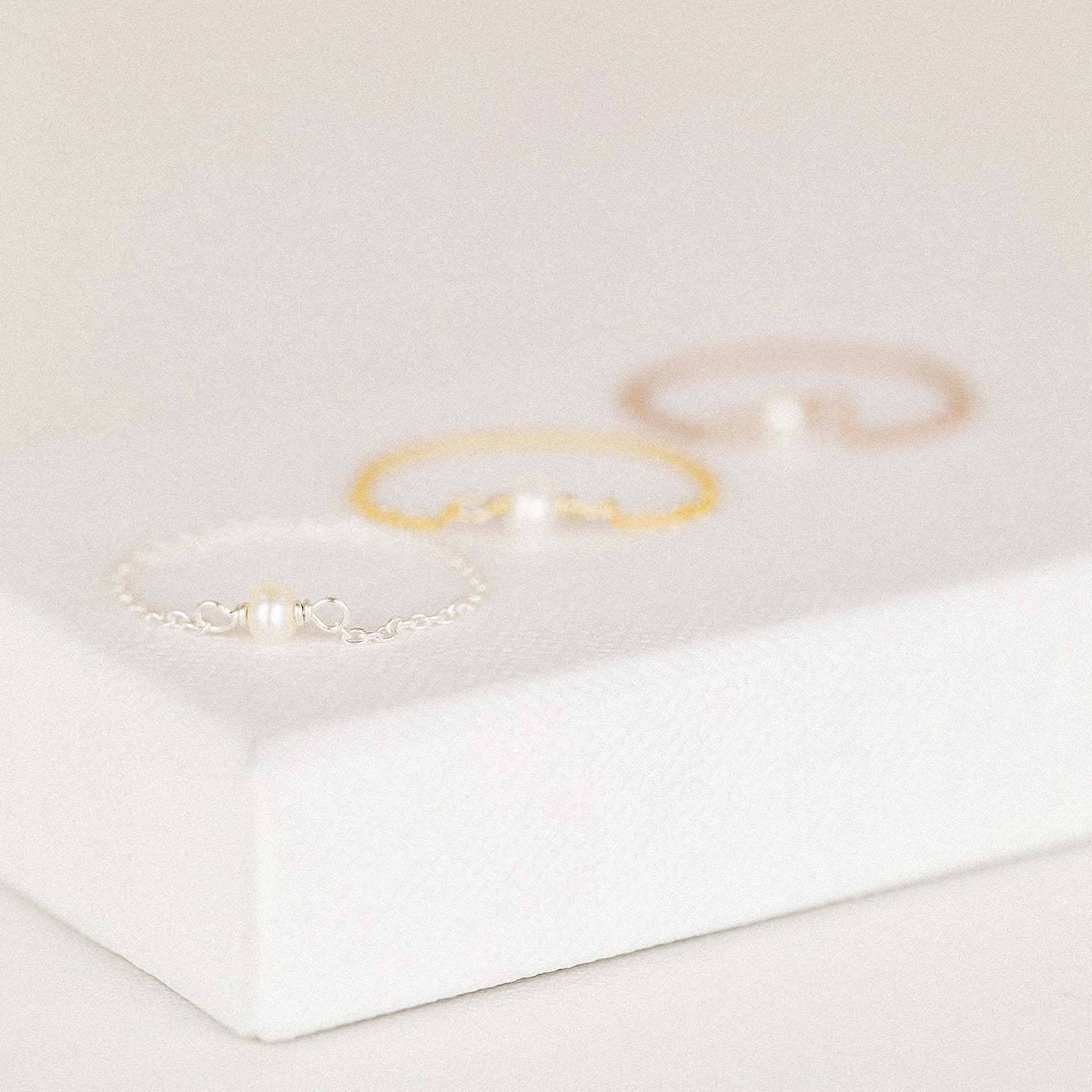 Sterling silver freshwater pearl chain ring displayed on white background