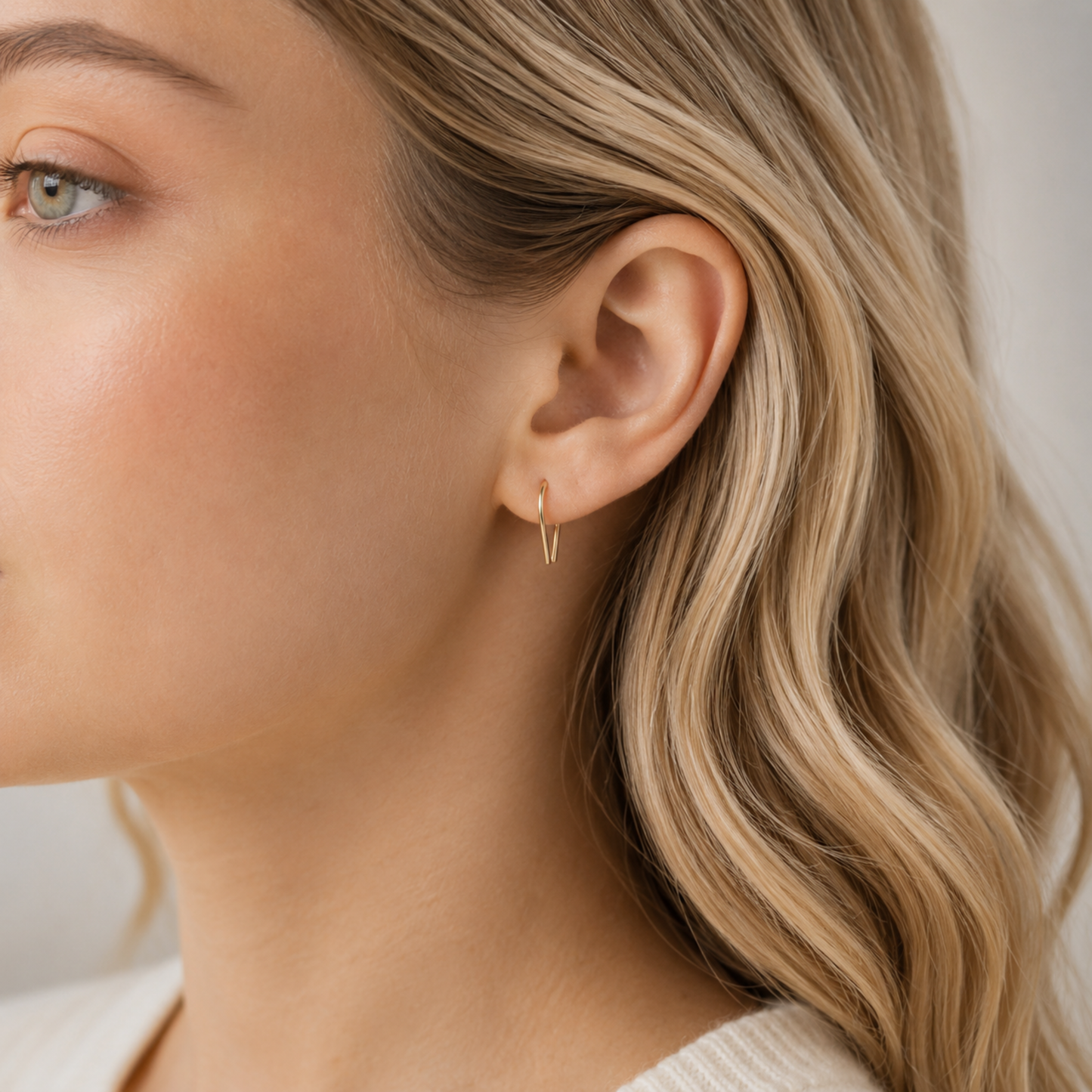 Close up of minimal U shape earrings styled for everyday wear