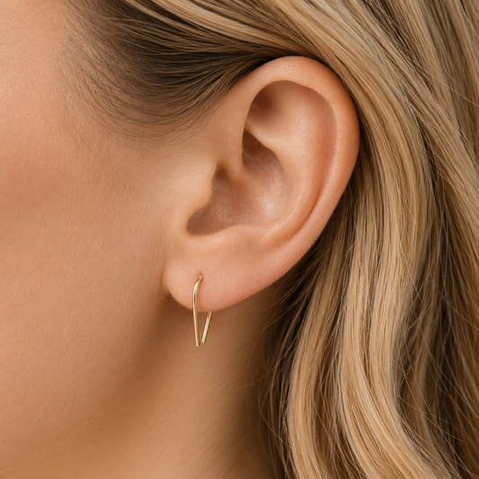 Side profile of modern U shaped earrings worn on earlobe