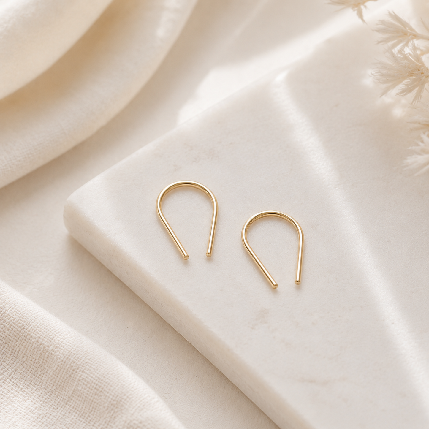 Pair of U shape earrings displayed on marble surface