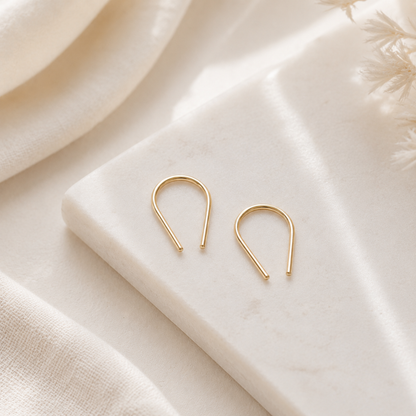 Pair of U shape earrings displayed on marble surface