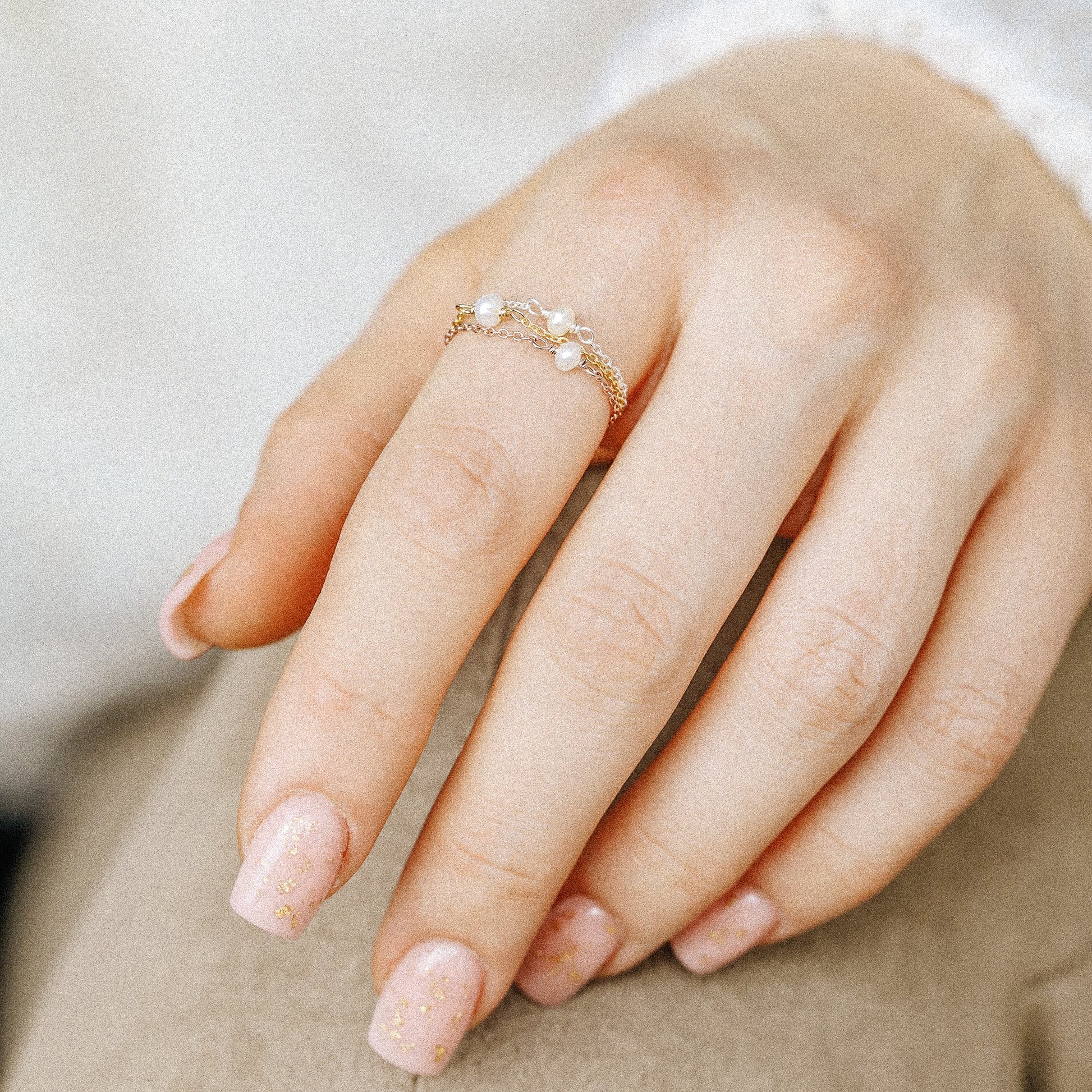 Dainty pearl chain ring worn as minimalist stacking jewelry