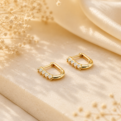 Gold opal huggie earrings showing the polished rectangular shape and secure closure