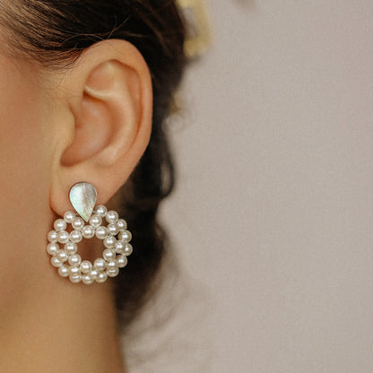 Pearl hoop dangle earrings worn in golden hour light with elegant statement look