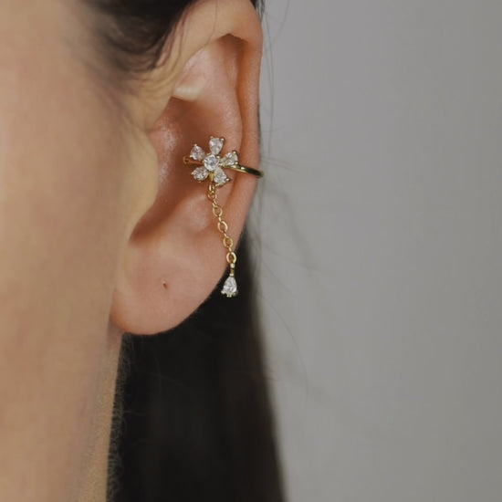 Sparkling flower ear cuff with dainty drop chain in 18k gold plated sterling silver and 925 silver, worn on cartilage without piercing.