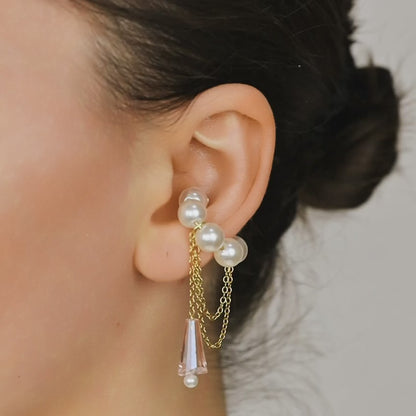 Dainty pearl crystal conch ear cuff shown as a no-piercing cartilage accessory, featuring artificial pearls around the conch area, delicate draped chains and a dangling faceted crystal drop, handmade and available in sterling silver 925, 14k gold filled or 14k rose gold filled.