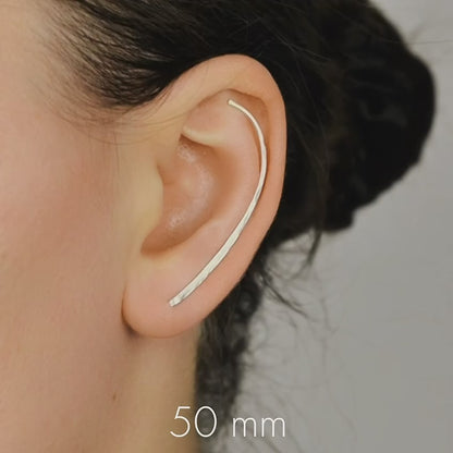 Handmade 50 mm minimalist ear climber earrings worn through one standard lobe piercing and rotated upward to follow the natural curve of the ear, featuring a long clean hand hammered wire design with an elegant ear sweep shape, available as a single left ear climber, single right ear climber or pair in solid 925 sterling silver, 14k gold filled and 14k rose gold filled, with length options from 10mm to 50mm.