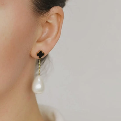 Close up of black clover pearl drop earring with gold chain and luminous teardrop pearl