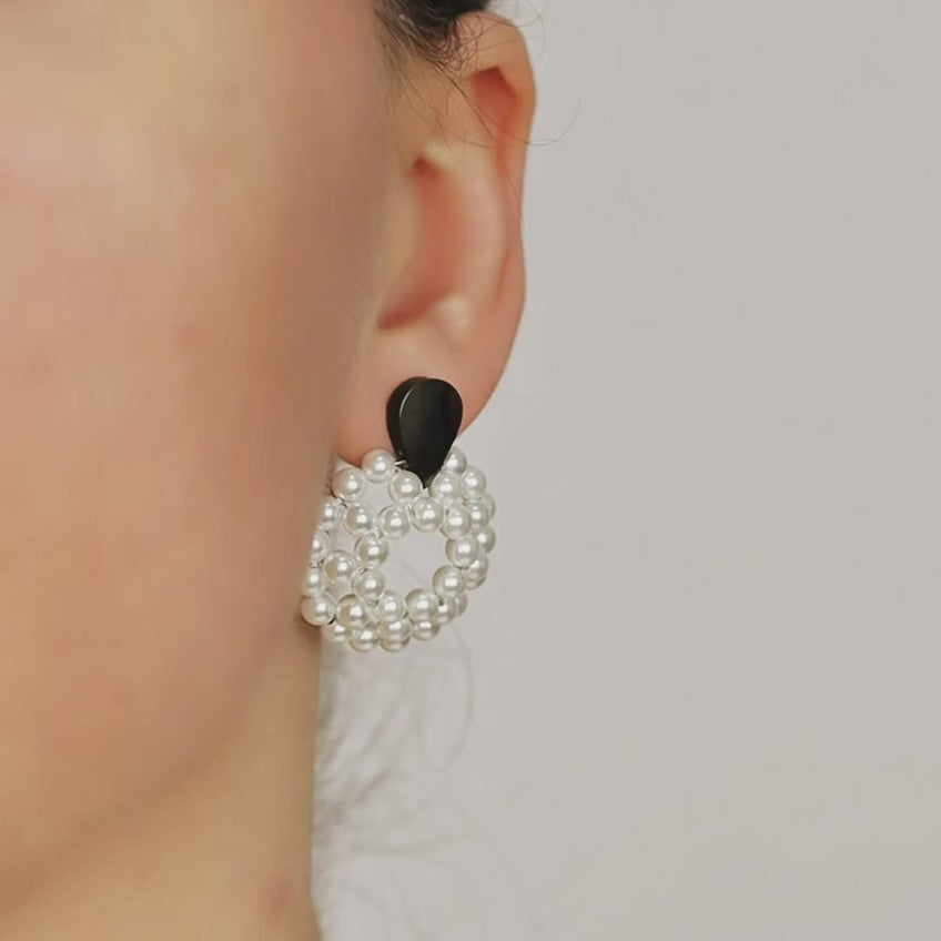Pearl hoop dangle earrings worn in golden hour light with elegant statement look