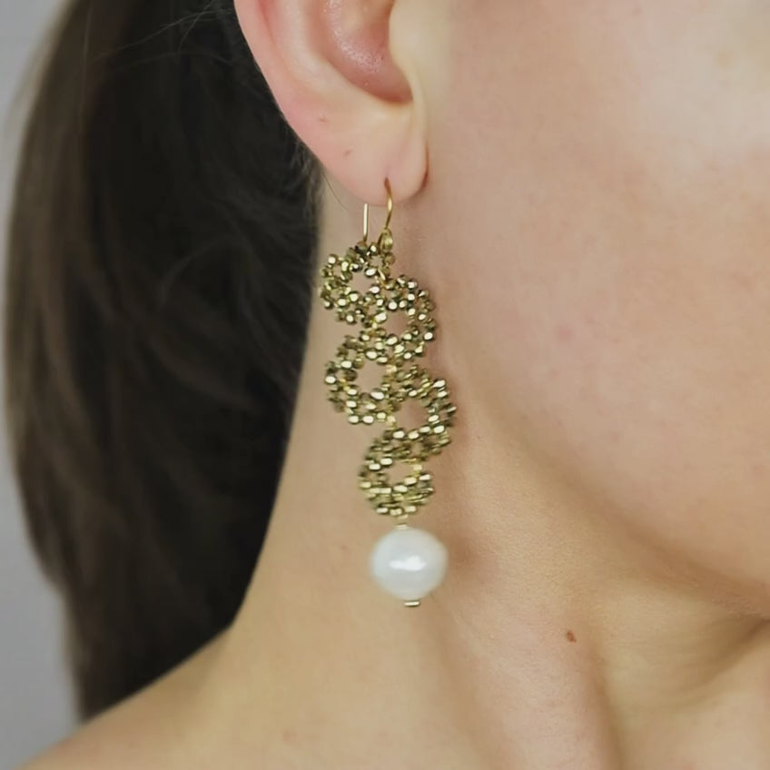 Long gold beaded snake earrings with pearl drop worn on the ear