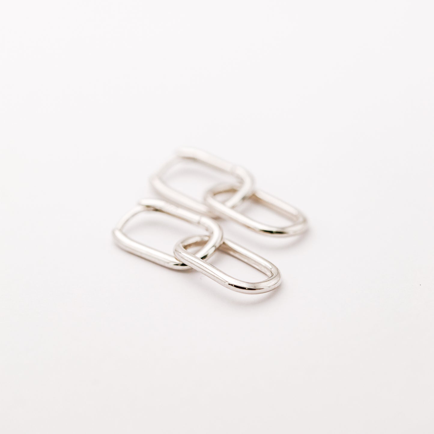 Pair of silver double open-link hoop earrings displayed on white background