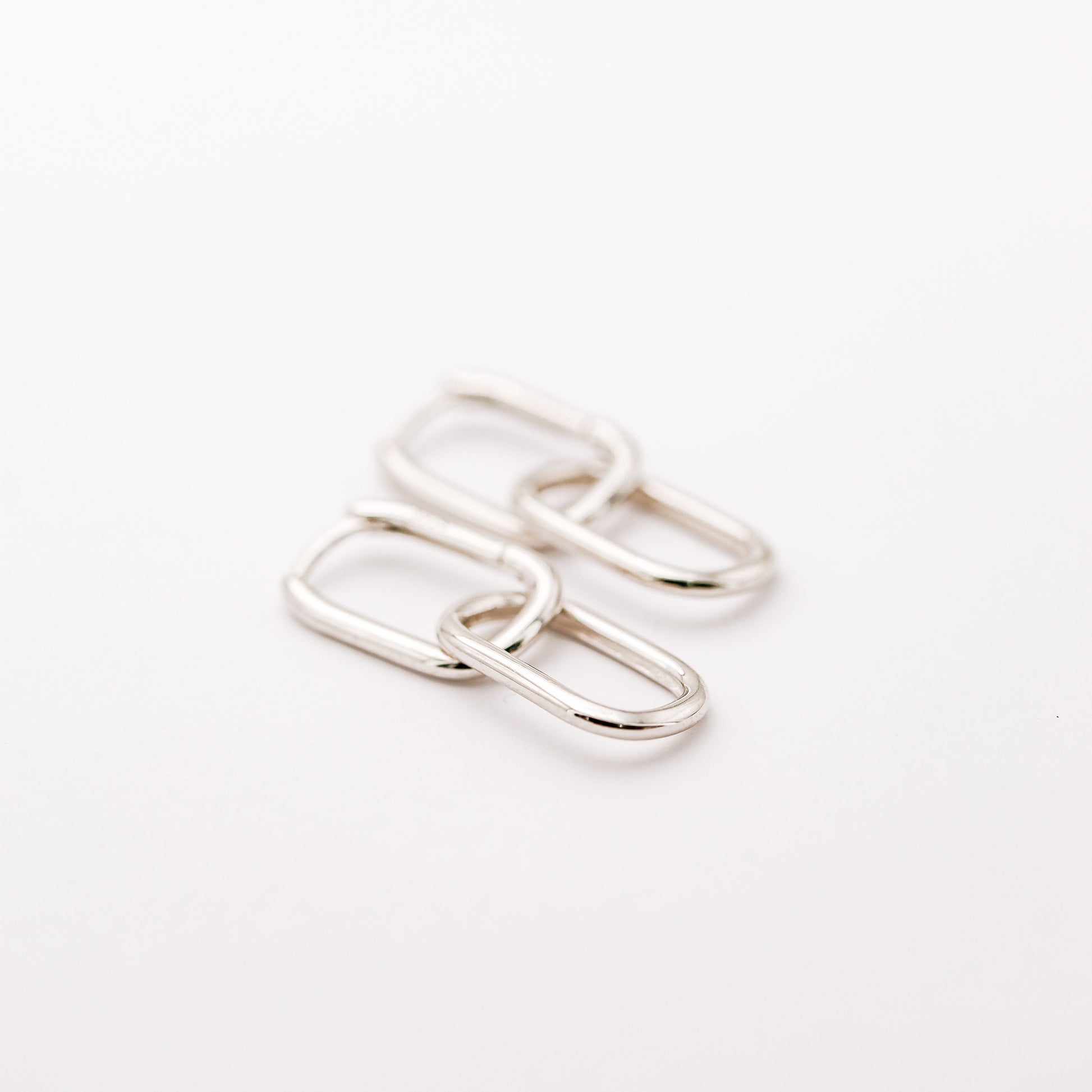 Pair of silver double open-link hoop earrings displayed on white background