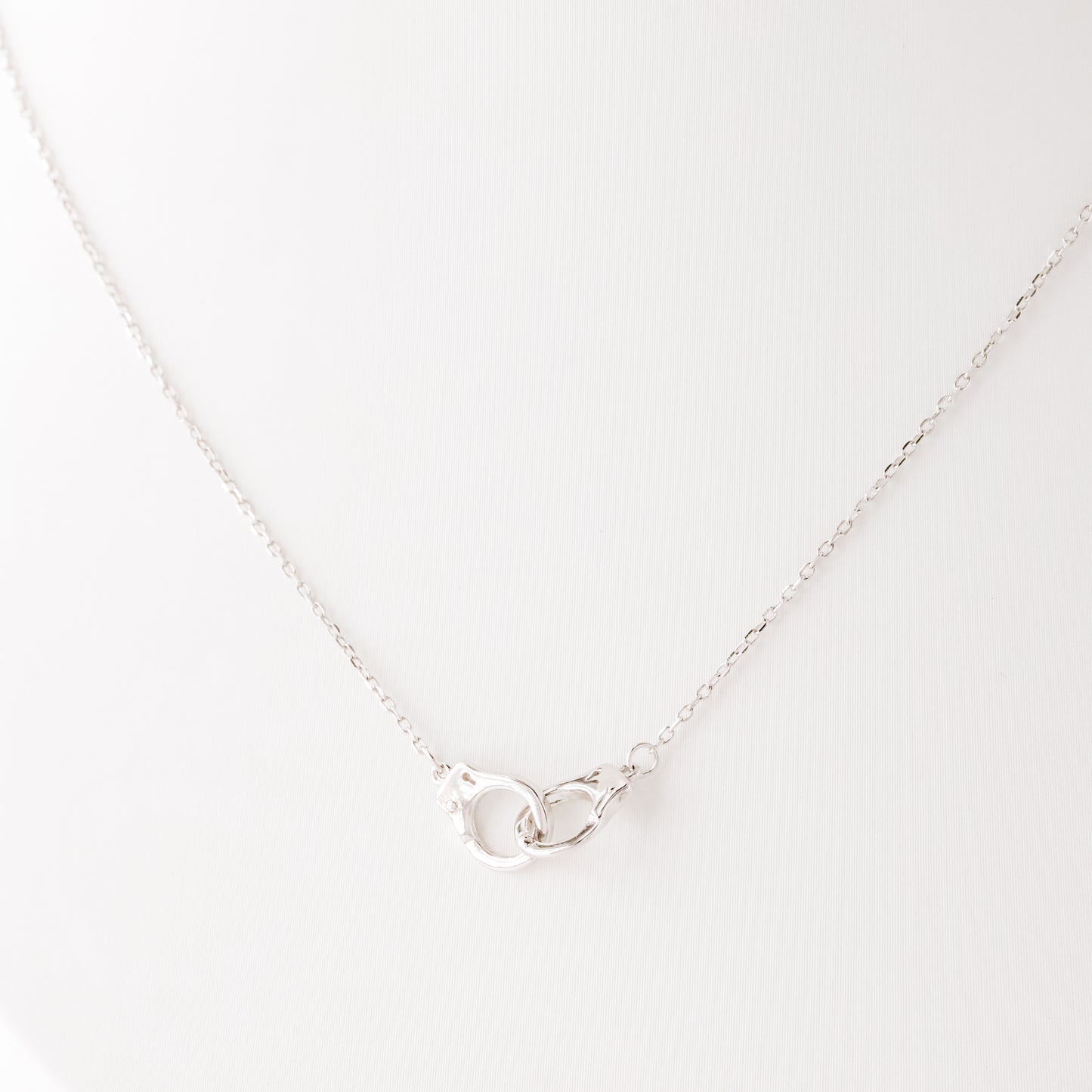 Close up detail of sterling silver handcuff pendant necklace on delicate chain