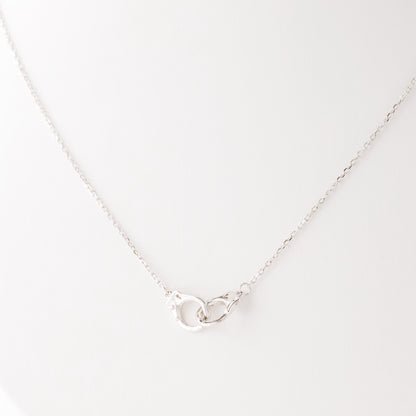 Close up detail of sterling silver handcuff pendant necklace on delicate chain