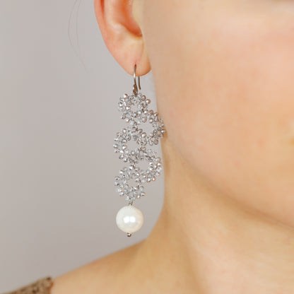 Elegant silver iridescent serpentine earrings worn with long cascading dangle design