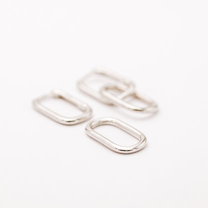 Silver hinged hoop earrings showing the polished geometric double link design