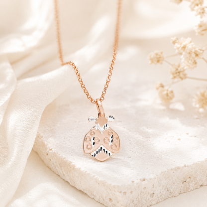Close up of diamond cut ladybug pendant showing polished silver and rose gold details