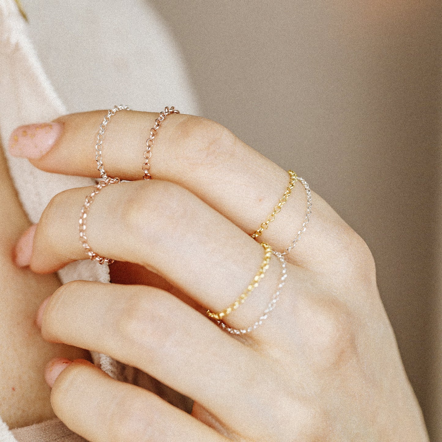 Rose gold chain ring worn on hand