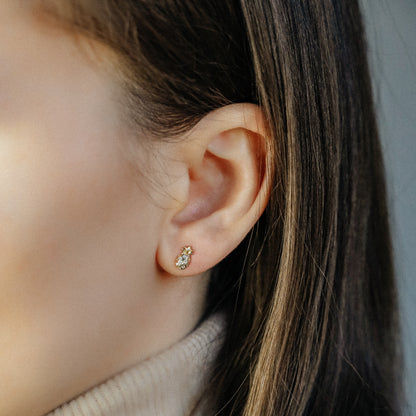 Tiny pineapple stud earrings worn on ear in 18k gold plated sterling silver