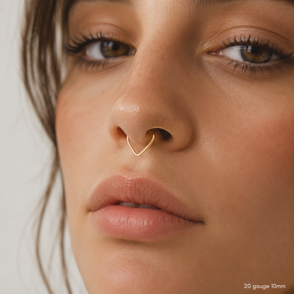 Close-up model photo featuring a delicate V-shaped gold septum hoop.